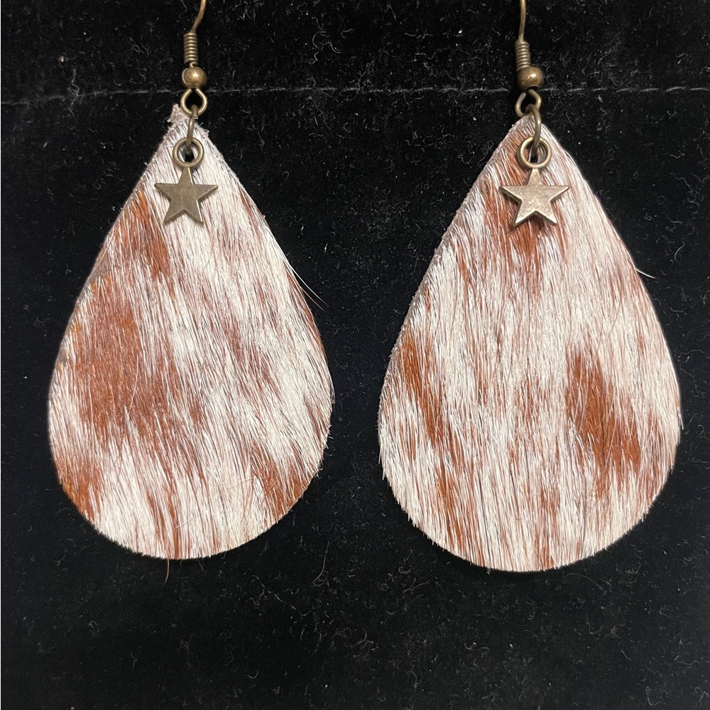 Cow hide earrings with a star charm.